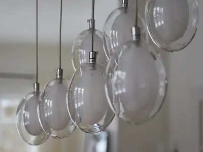 A cluster of modern glass pendant lights installed in a bright living space.